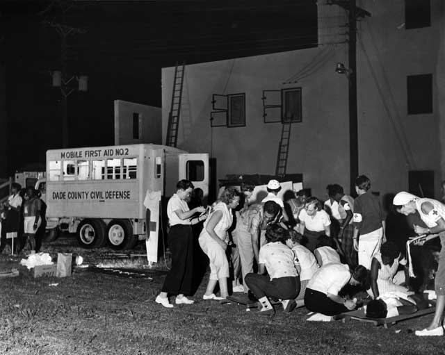 A group of African American and white citizens take part in a nighttime Dade County Civil Defense first aid drill. January 14, 1960. Miami News Collection, Museum of Miami. 1995-277-5212.