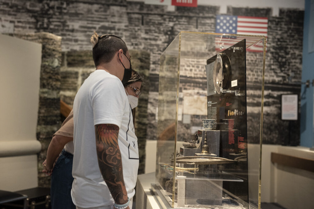 Two people wear medical face masks as they view a display case in the museum's Tropical Dreams exhibition.