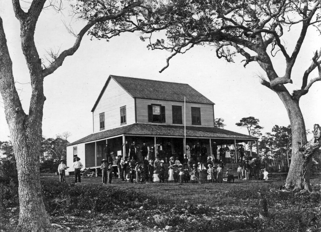 Men, women and children gathered in front of the Bay View House (later called the Peacock Inn), Coconut Grove. Many of the children are holding toys.