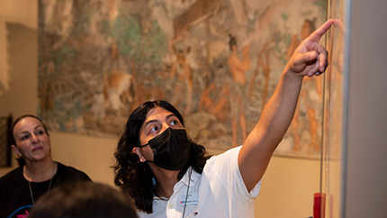 An adult pointing at a wall