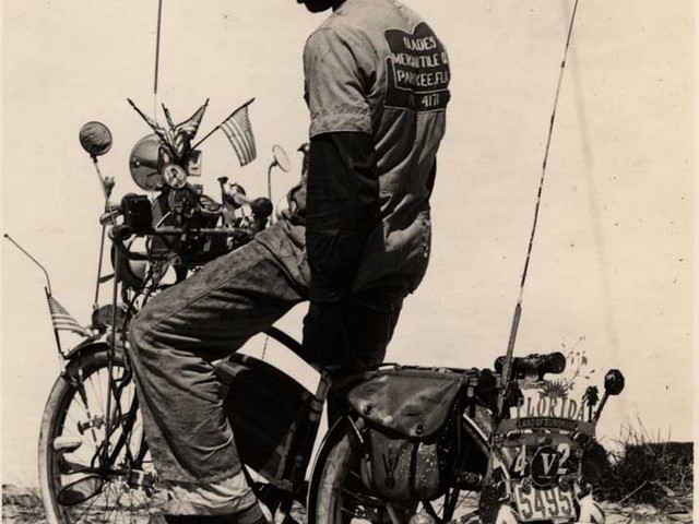 black man standing on an unmoving motorcycle