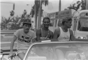black and white image of men riding in a convertible car
