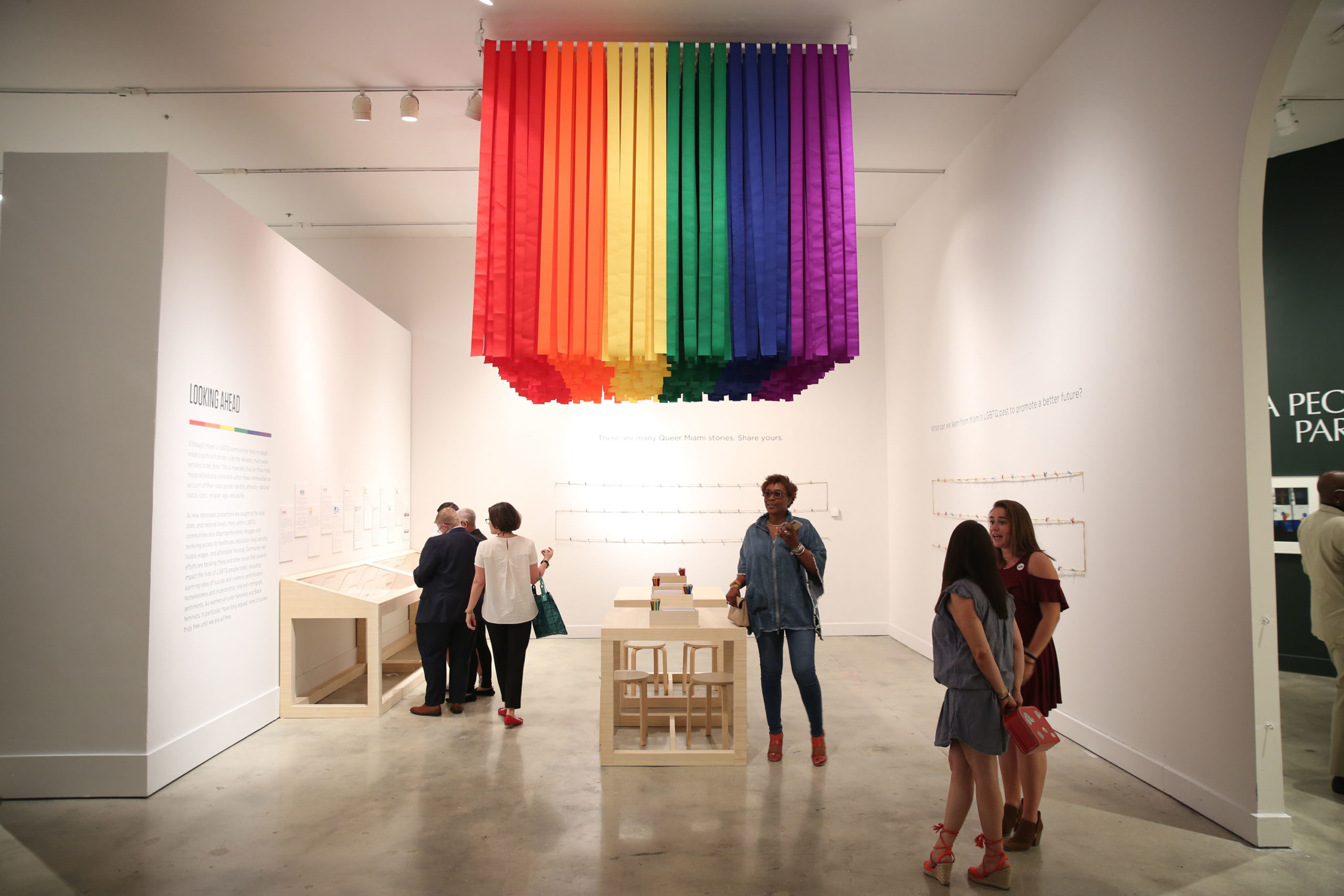 people walking around rainbow flag